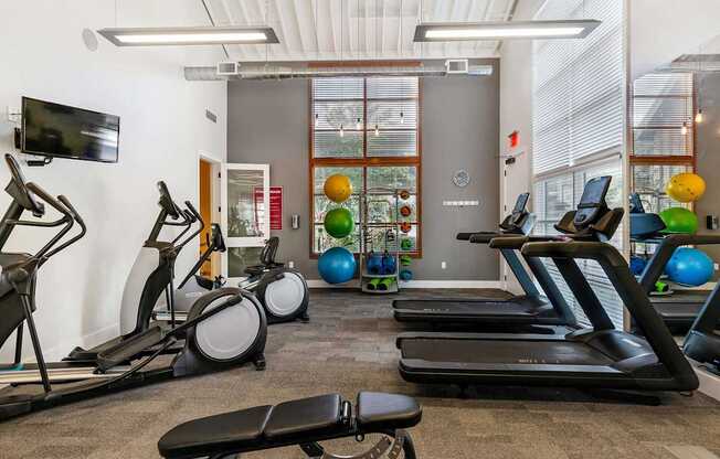 a gym with treadmills and other exercise equipment and a window