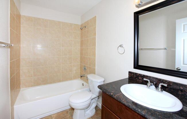 a white sink sitting under a mirror