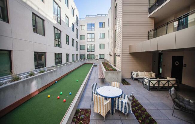 A patio with a table and chairs is surrounded by buildings.
