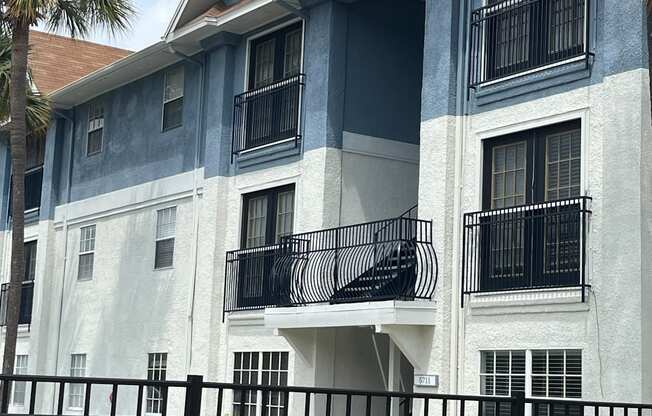 an apartment building with a red car parked in front of it