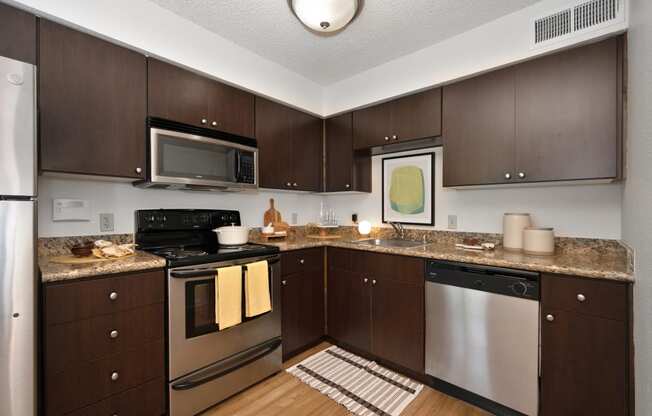 a kitchen with dark wood cabinets and stainless steel appliances