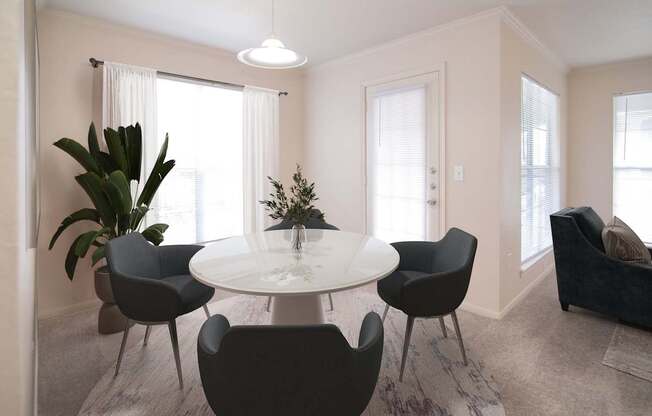 A modern dining room with a round table and chairs.
