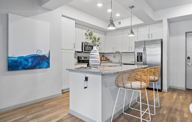 a kitchen with an island and a bar with stools