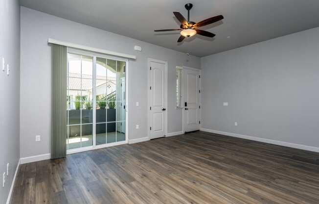 an empty living room with a ceiling fan