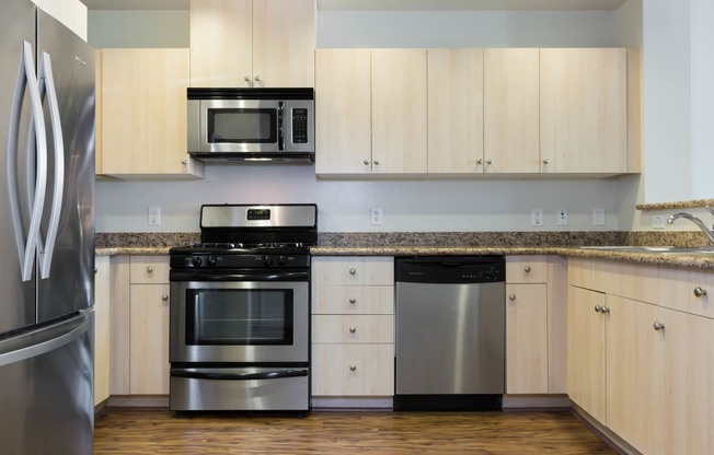 Oakland CA Apartments - Aqua Via - White Kitchen with Granite Countertops, Stainless Steel Appliances & Wood-Style Flooring