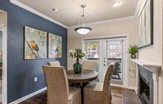 A dining room with a table and chairs.
