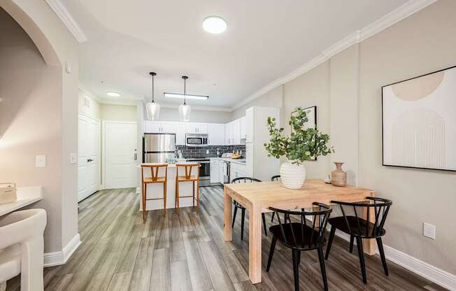 A kitchen with a table and chairs in the middle of the room.