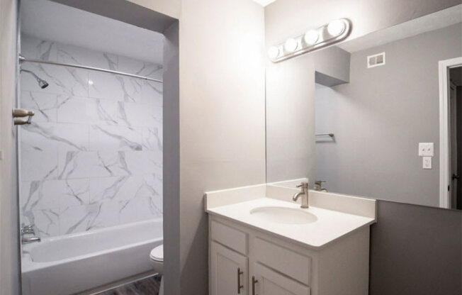 a bathroom with a sink and a bathtub at Station JTown, Louisville, KY 40299