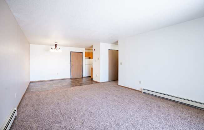 A room with a carpeted floor and a white wall.