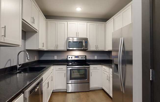 a kitchen with white cabinets and stainless steel appliances