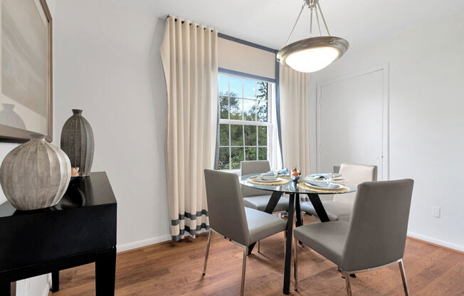 a dining room with a table and chairs and a window