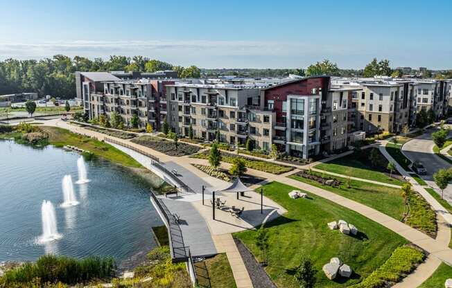 an aerial view of an apartment complex with a lake and fountain