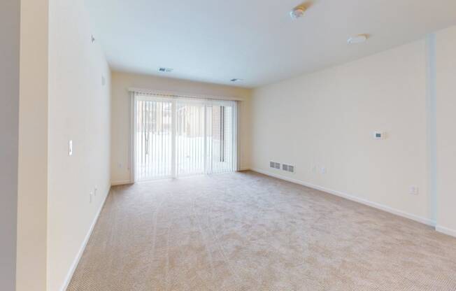 an empty living room with a door to a balcony