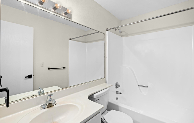 Gold bathroom interior with tub at The Arbor Apartments in Blue Springs, Missouri