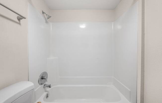 a white bathroom with a tub and a toilet and a sink