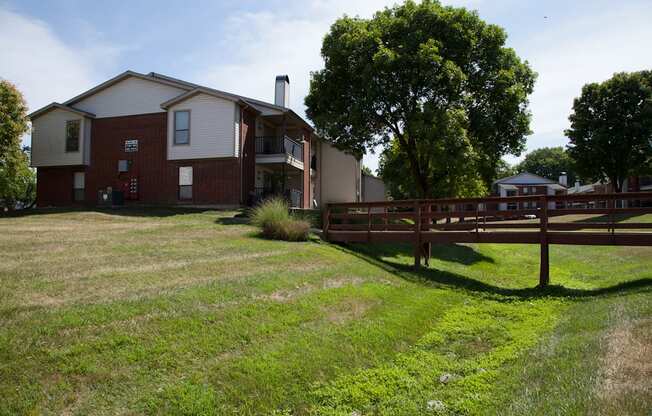 A red brick house with a white trim and a brown fence in front of it.