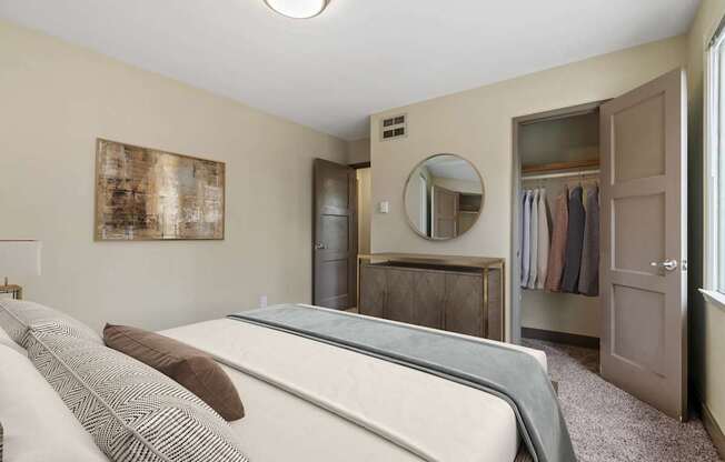 A bedroom with a bed, wardrobe, and a mirror.