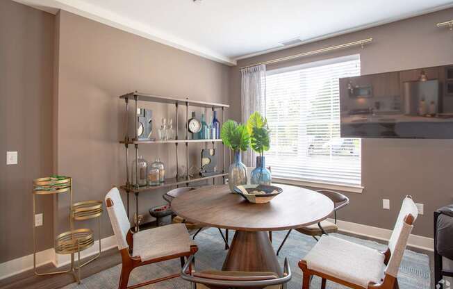A dining room with a round table and chairs.