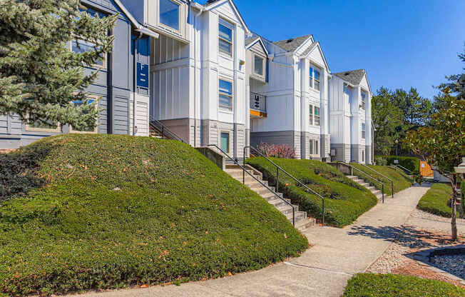 A white building with a green lawn in front.