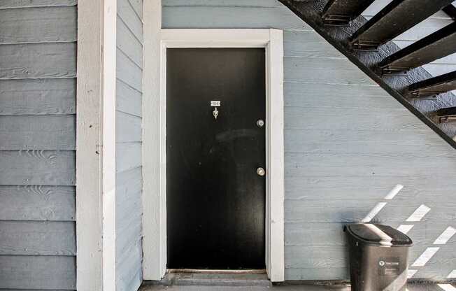 A black door is on the side of a house.