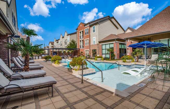 A pool surrounded by lounge chairs and umbrellas.