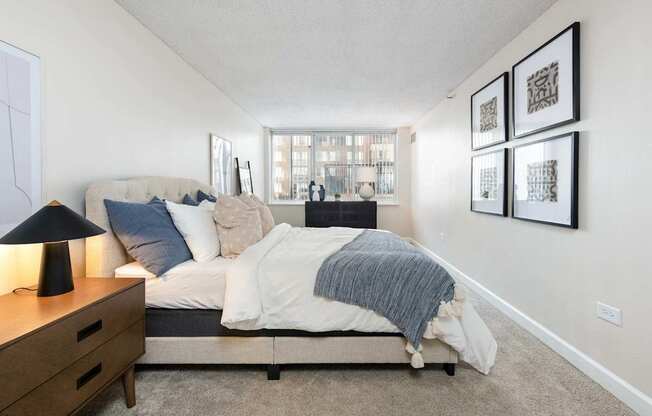 a bedroom with a bed and a dresser and a window