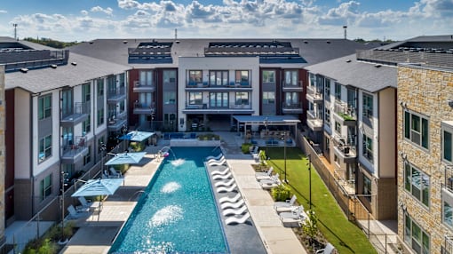 A swimming pool is surrounded by apartment buildings.