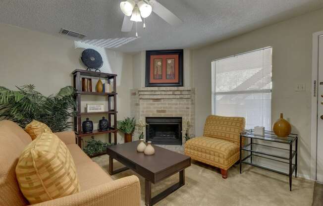 a living room with a fireplace and a ceiling fan