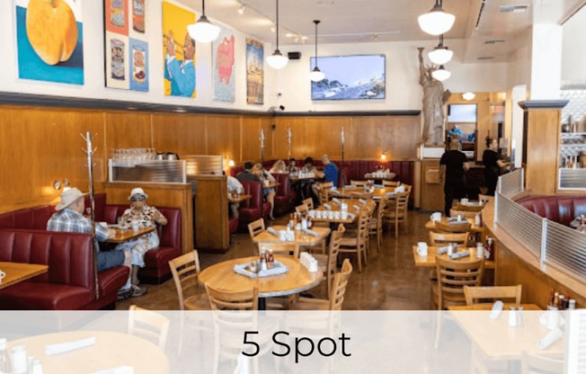 A restaurant with wooden booths and tables with people sitting and eating.
