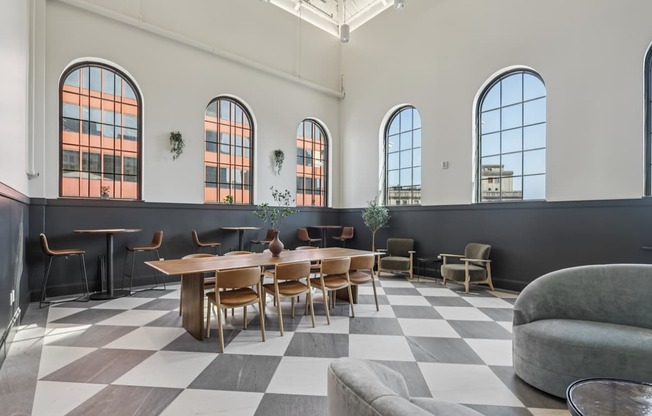 A large room with a checkered floor and a long table with chairs.