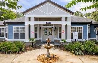 A blue building with a fountain in front of it.