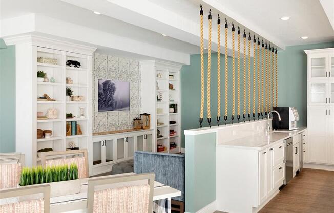 A kitchen with a white table and chairs and a blue wall.