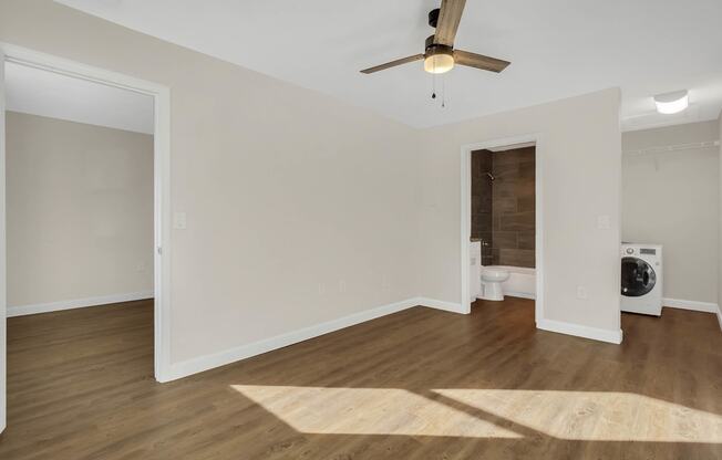 photo of a living room with a ceiling fan and a washer and dryer