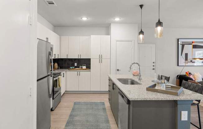 A modern kitchen with a large island and stainless steel appliances. at Bridge at Tech Crossing, Austin, Texas