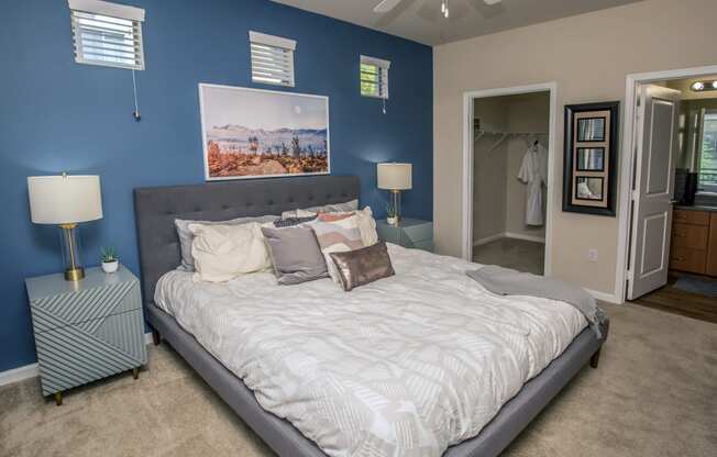 a bedroom with a large bed and a blue wall