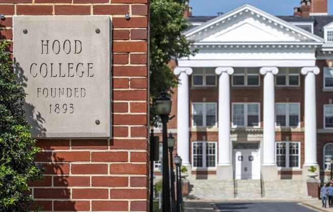 A sign on a brick wall that says Hood College Founded 1893.