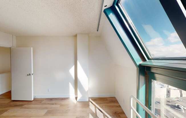 a living room with a large window and wooden floors