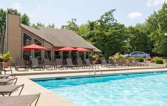 The pool area at Skyler Ridge Apartments, featuring clear blue water and plenty of lounge chairs for residents to enjoy.