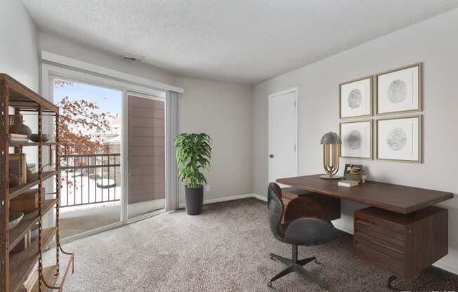 an office with a sliding glass door and a desk with a chair at Eastwood Crossings, Kansas City