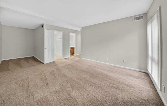 A room with a carpeted floor and a doorway leading to another room.