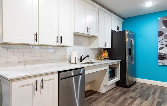 a kitchen with white cabinets and a stainless steel refrigerator