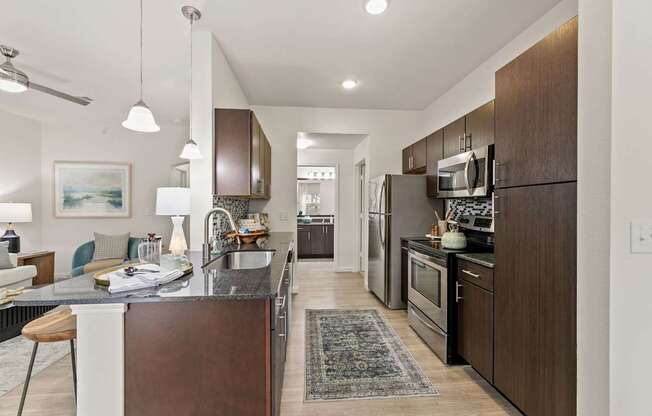 A modern kitchen with dark wood cabinets and a white island.