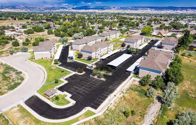 A large parking lot is surrounded by apartment buildings.