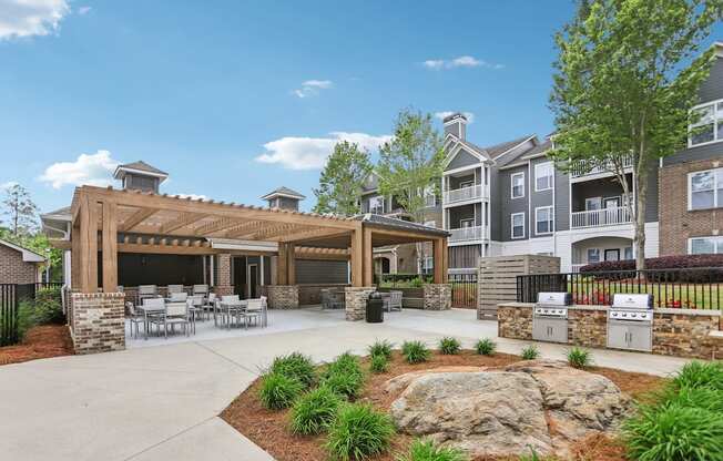 A large outdoor patio area next to the pool with tables and grills.