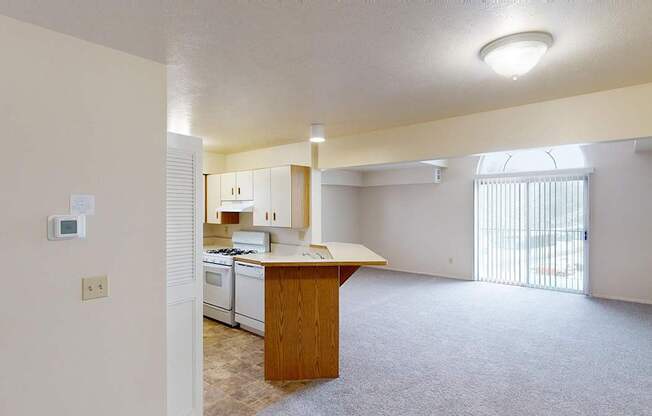 A kitchen and an enlarged living room with a cathedral ceiling at Foxwood and The Hermitage, Portage, MI