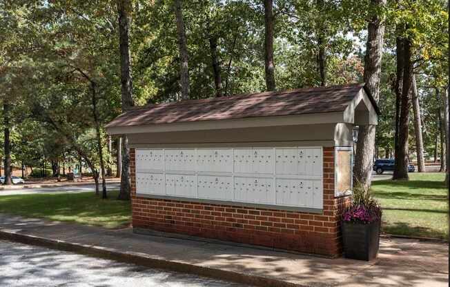 A small building with a calendar on the wall and a tree in front of it.