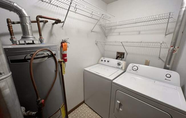 A laundry room with a washer and dryer and a hose.