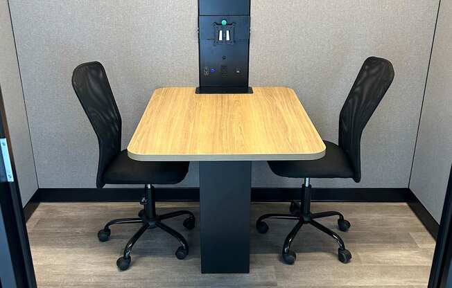 Study pod interior with desk and two chairs