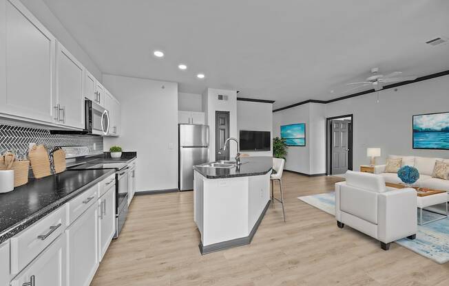A modern kitchen with white cabinets and a black countertop.