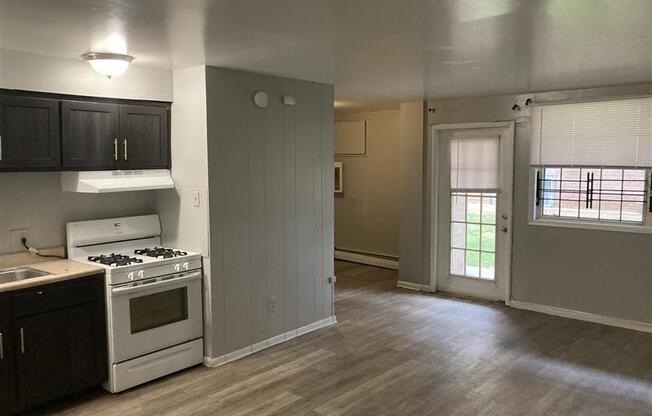 A kitchen with a white stove and black cabinets.